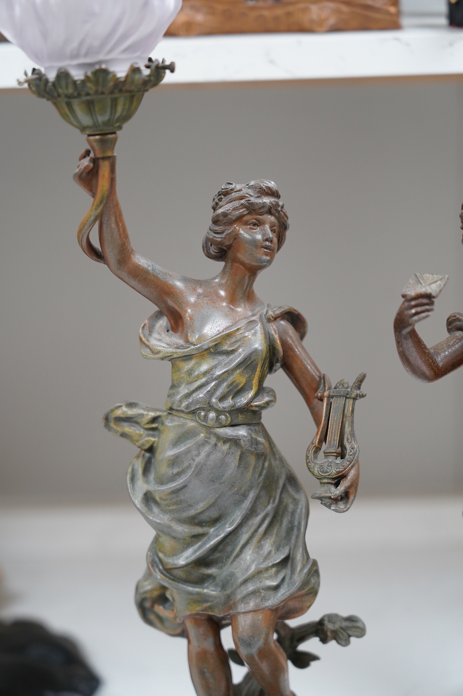 After Guillemin (1841-1907), a pair of spelter figural lamps with frosted glass shades, overall 61cm high. Condition - poor to fair, damage to glass